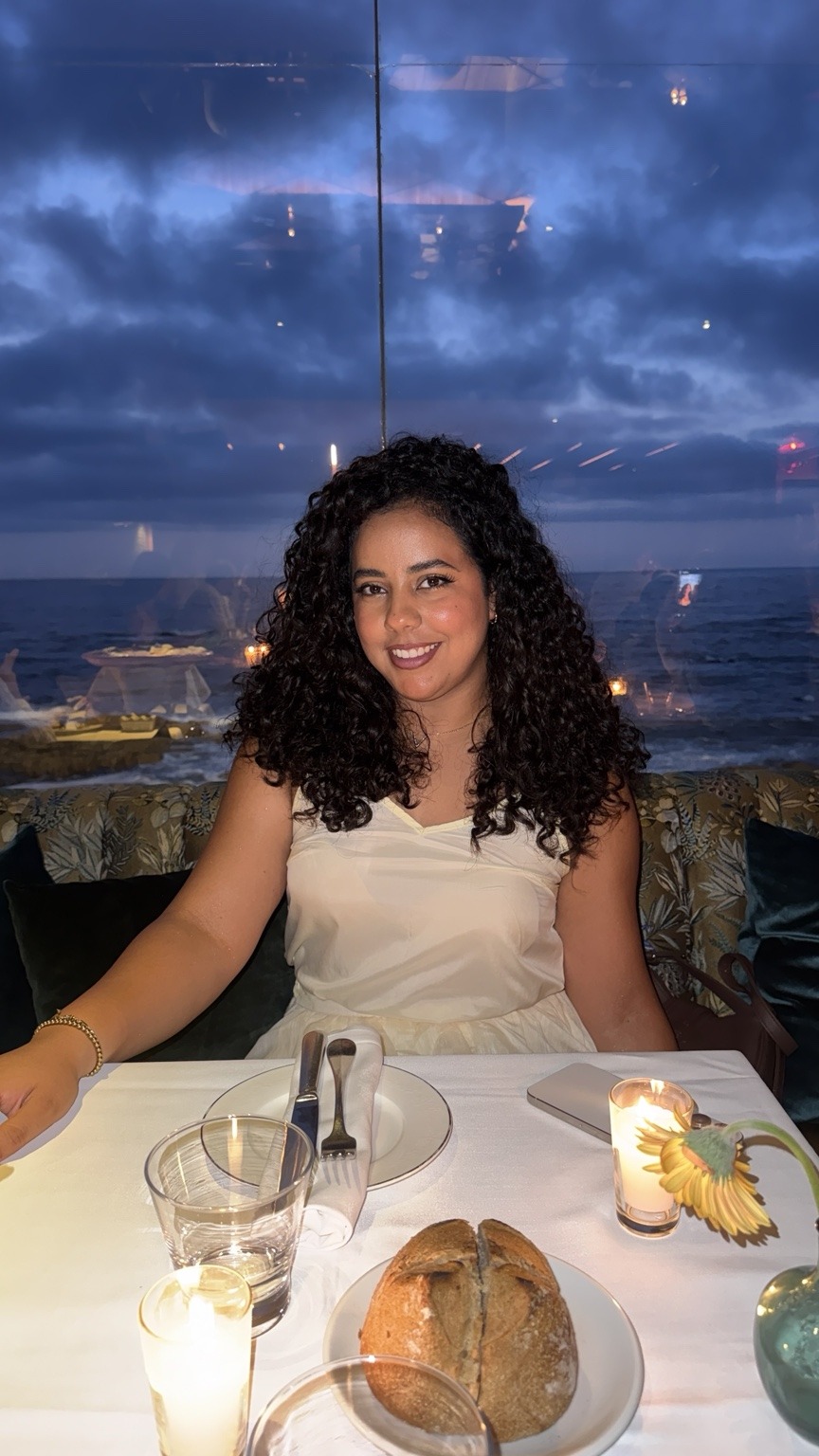 Zineb smiling in a white dress
